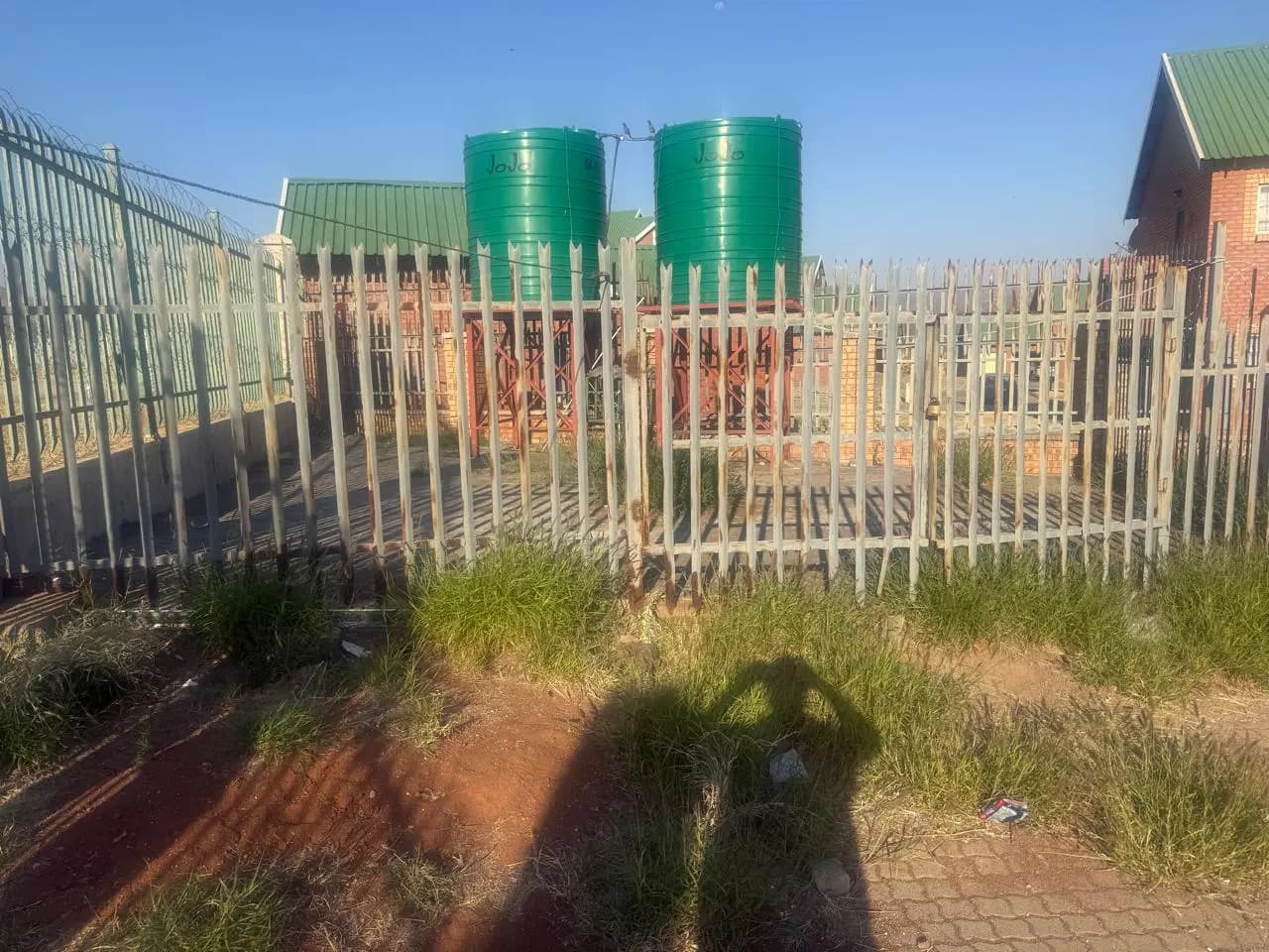 Large green water storage tanks installed behind security fencing
